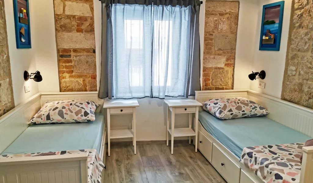 The interior of a small private room with two single beds in the CroParadise Hostel in Split, Croatia