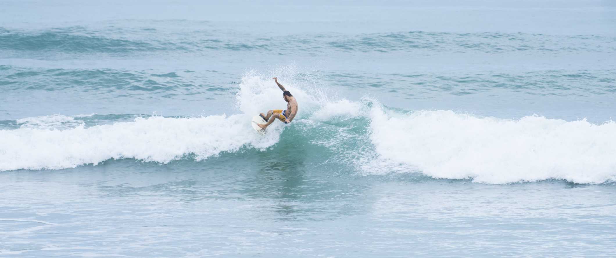 A surfer catches a wave off the coast of Tamarindo in Costa Rica