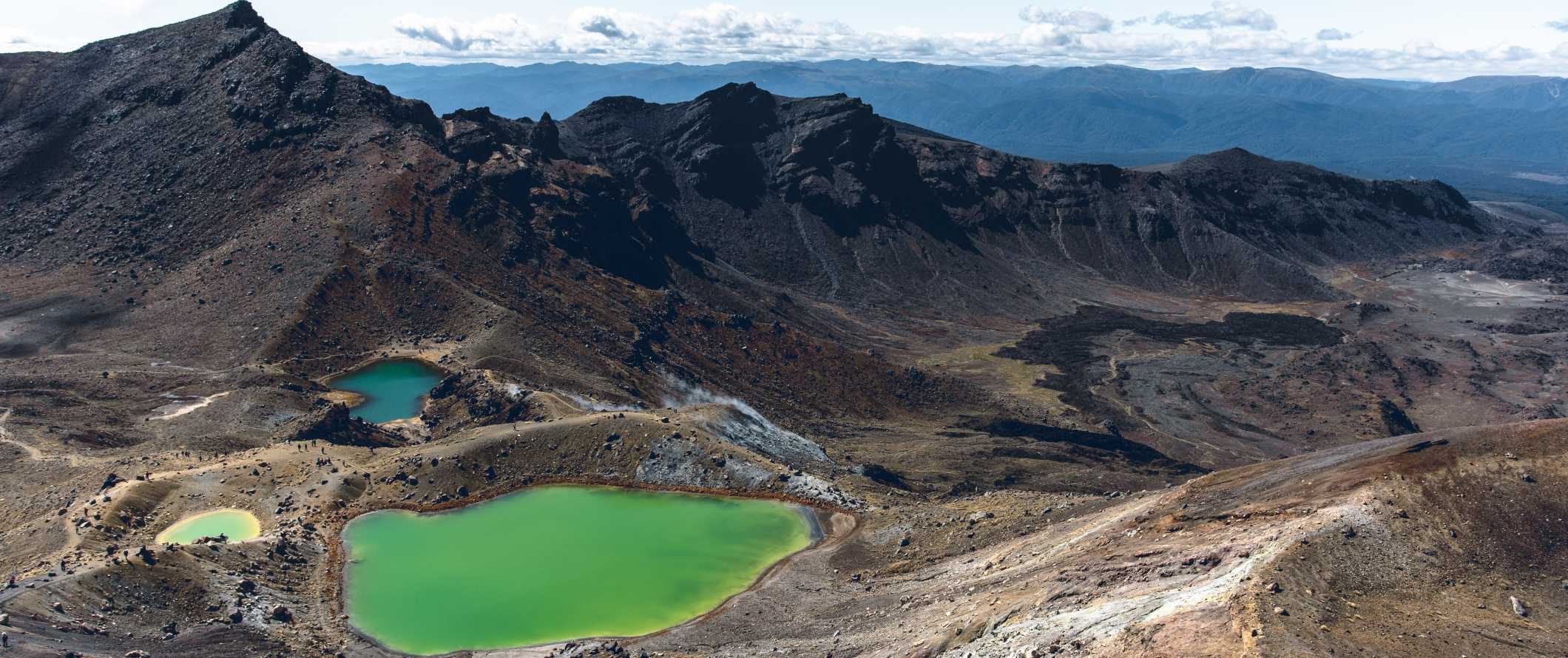 Dramatic volcanic landscapes with bright green lakes below, at Tongariro Alpine Crossing near Taupo, New Zealand.