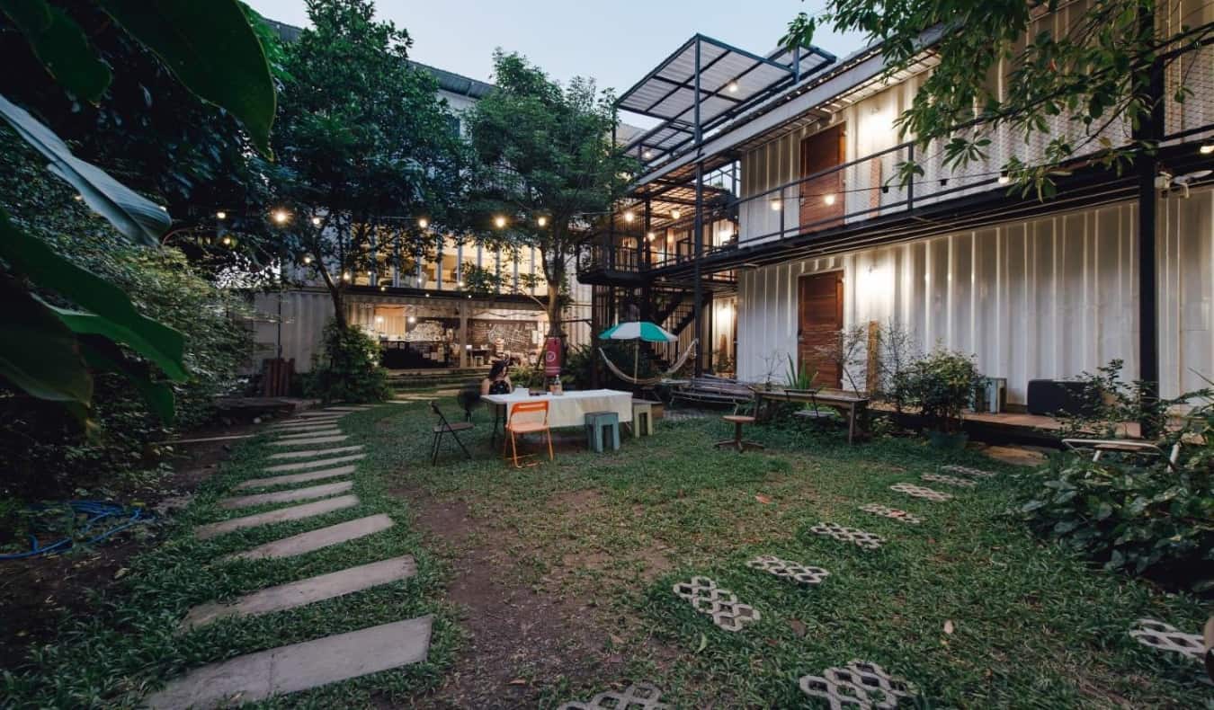 Large, lush backyard and shipping containers at the Yard Hostel Bangkok.