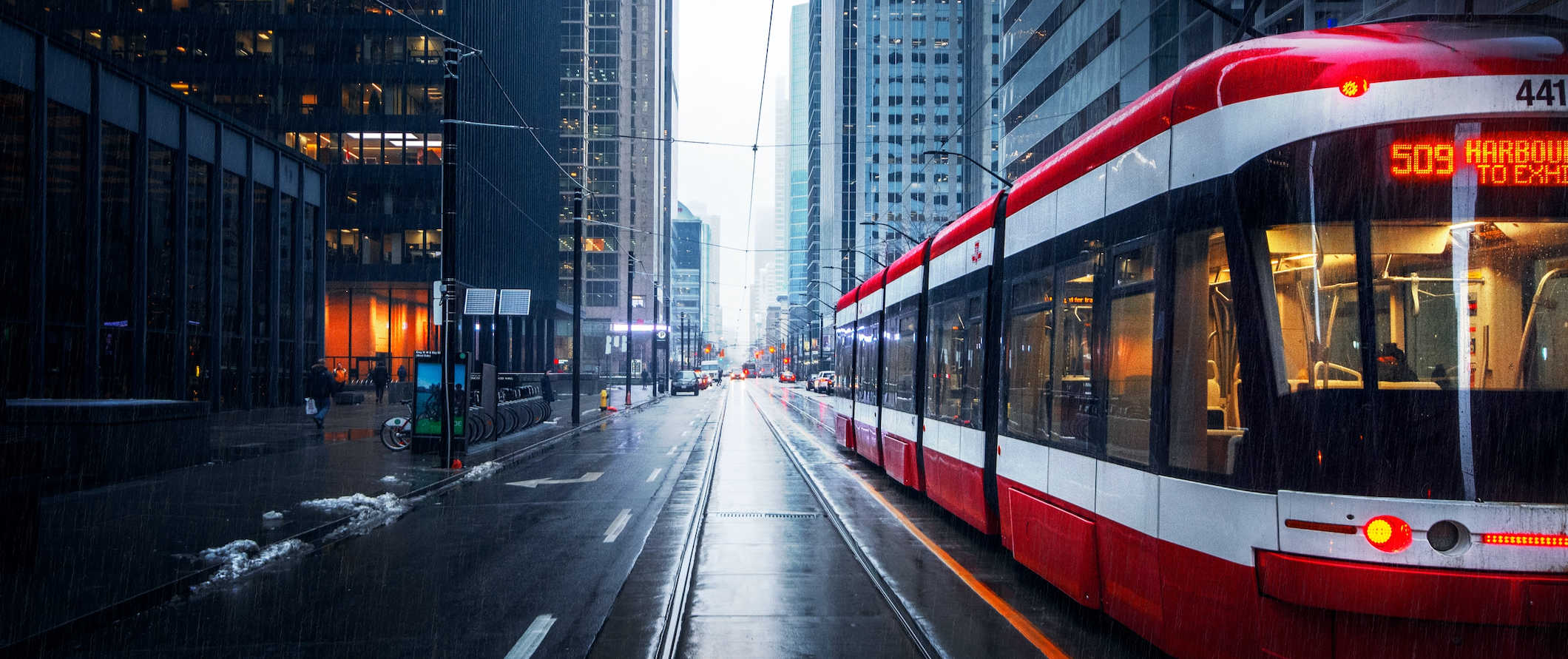 A TTC streetcar driving around downtown Toronto, Canada on a rainy day