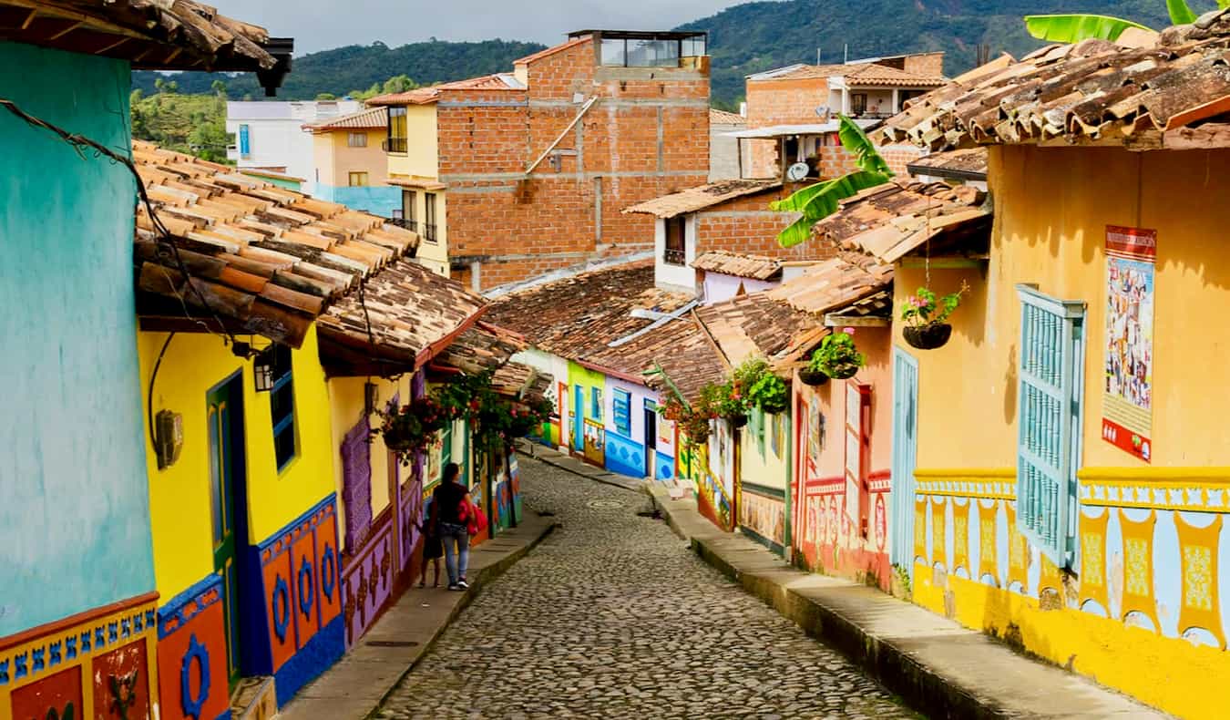 A colorful empty street in Colombia flanked by bright-painted houses