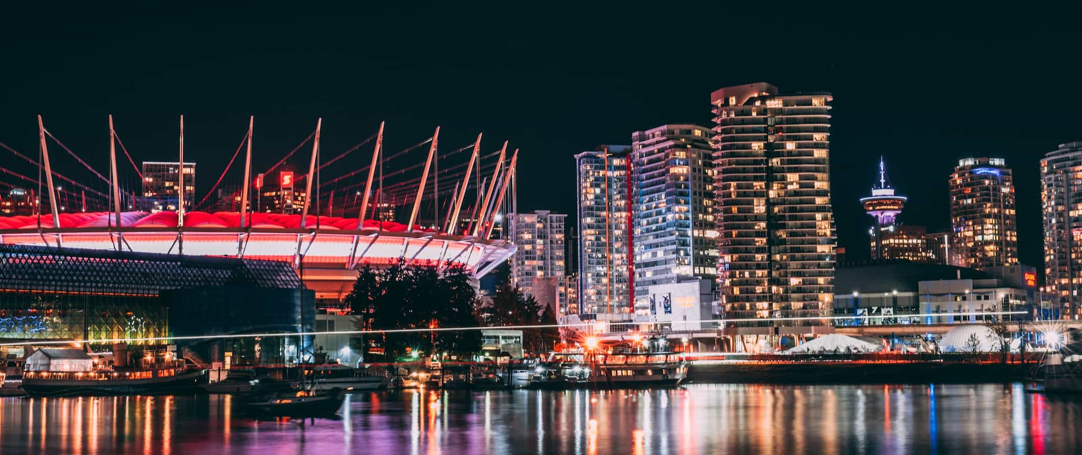 The skyline of Vancouver, Canada all lit up at night down near the water