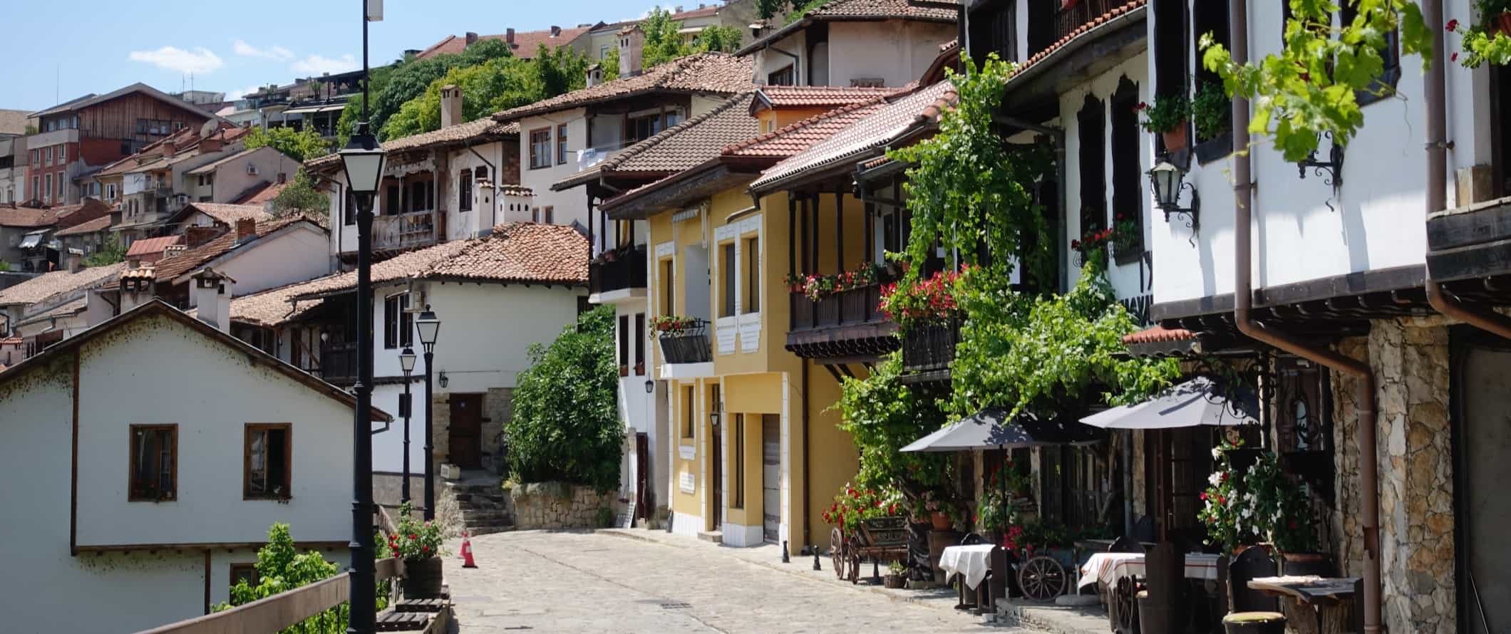 Cobblestone street lined with traditional houses and restaurants in the old town of Veliko Tarnovo, Bulgaria