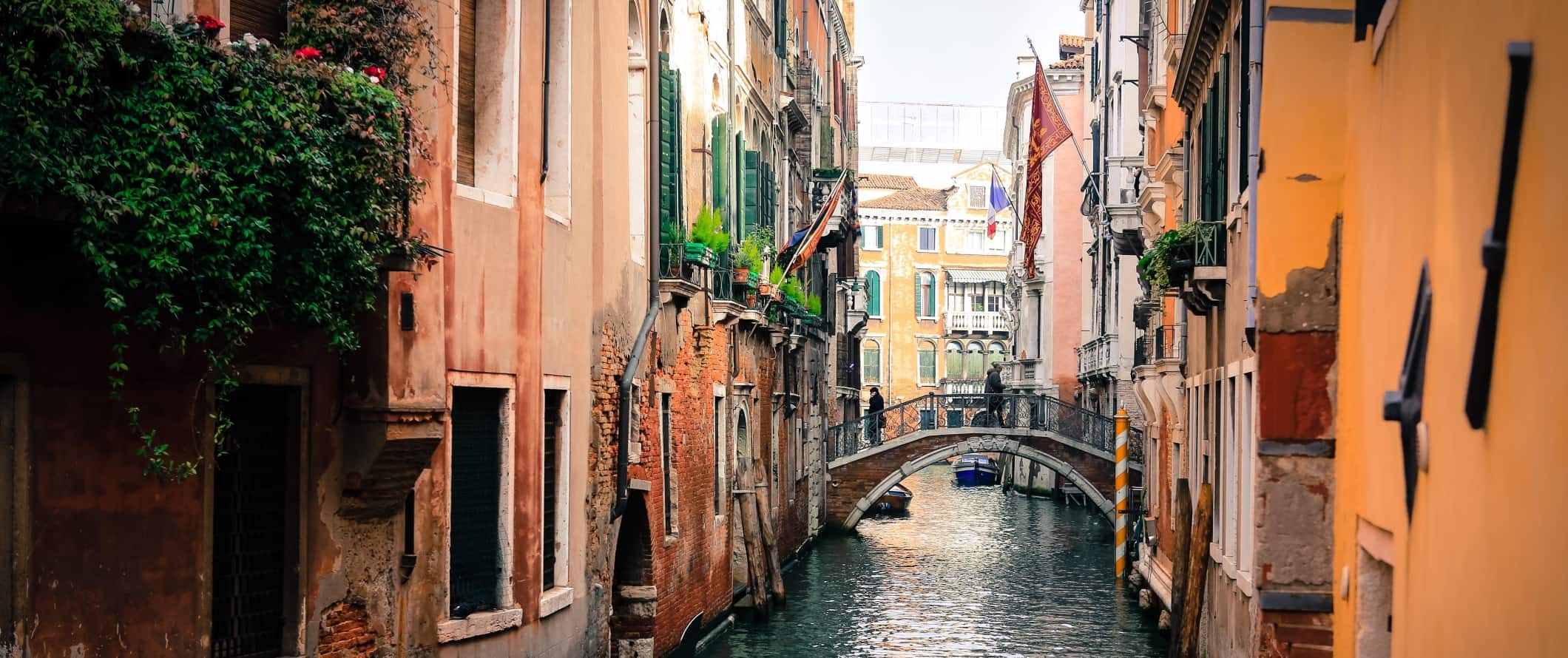 Closeup on colorful, historic homes lining a canal in Venice, Italy.