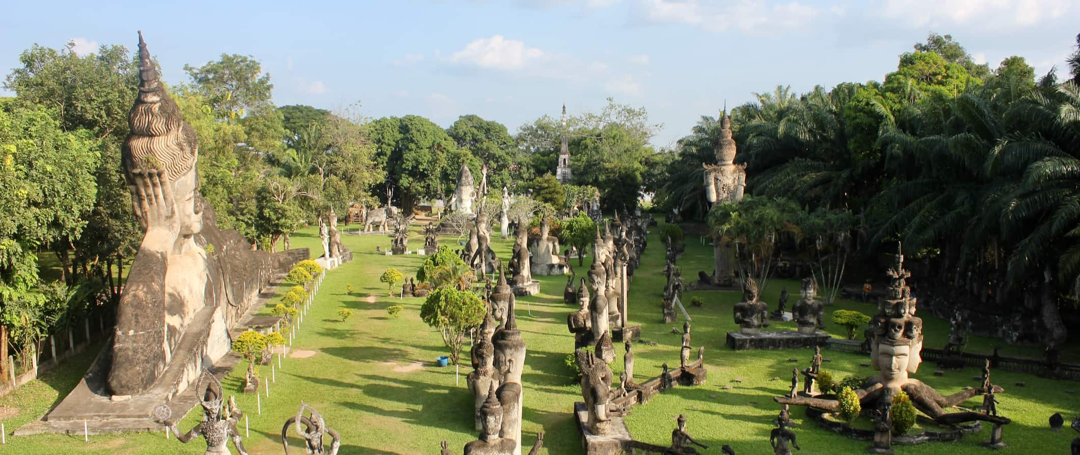 Dozens of Buddhist and Hindu states at Buddha Park near Vientiane, Laos surrounded by grass and trees