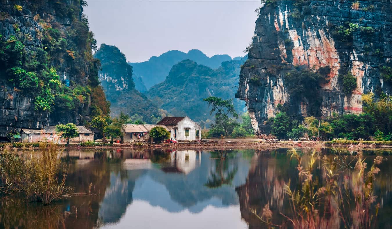 A small building on a hill near a lake in the countryside of Vietnam