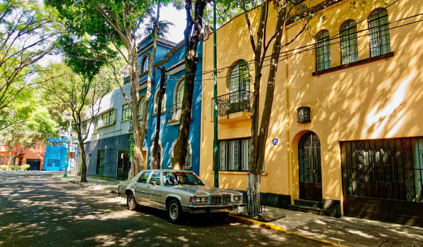 거리에 주차된 자동차가 있는 멕시코 시티 콘데사(Condesa)의 다채로운 주택이 있는 조용한 거리