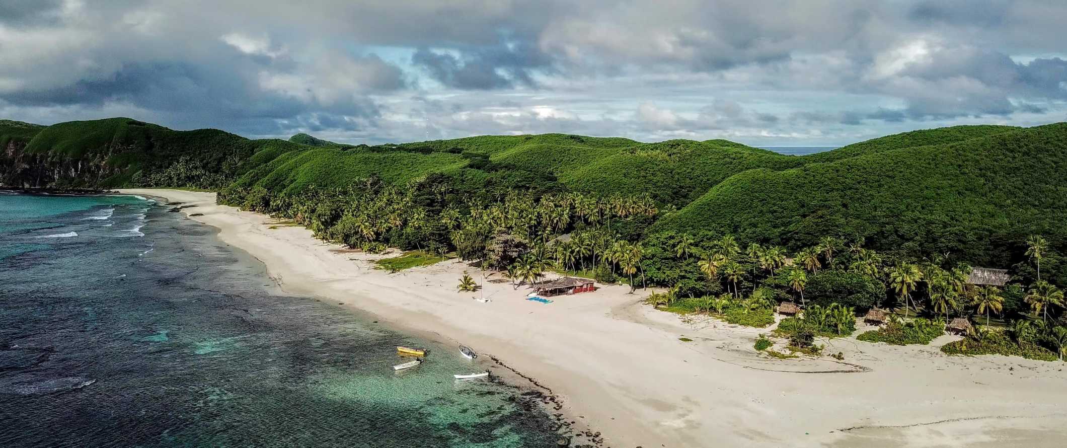 Aerial view of the beach and lush green jungles along the coast of the Yasawa Islands in Fiji