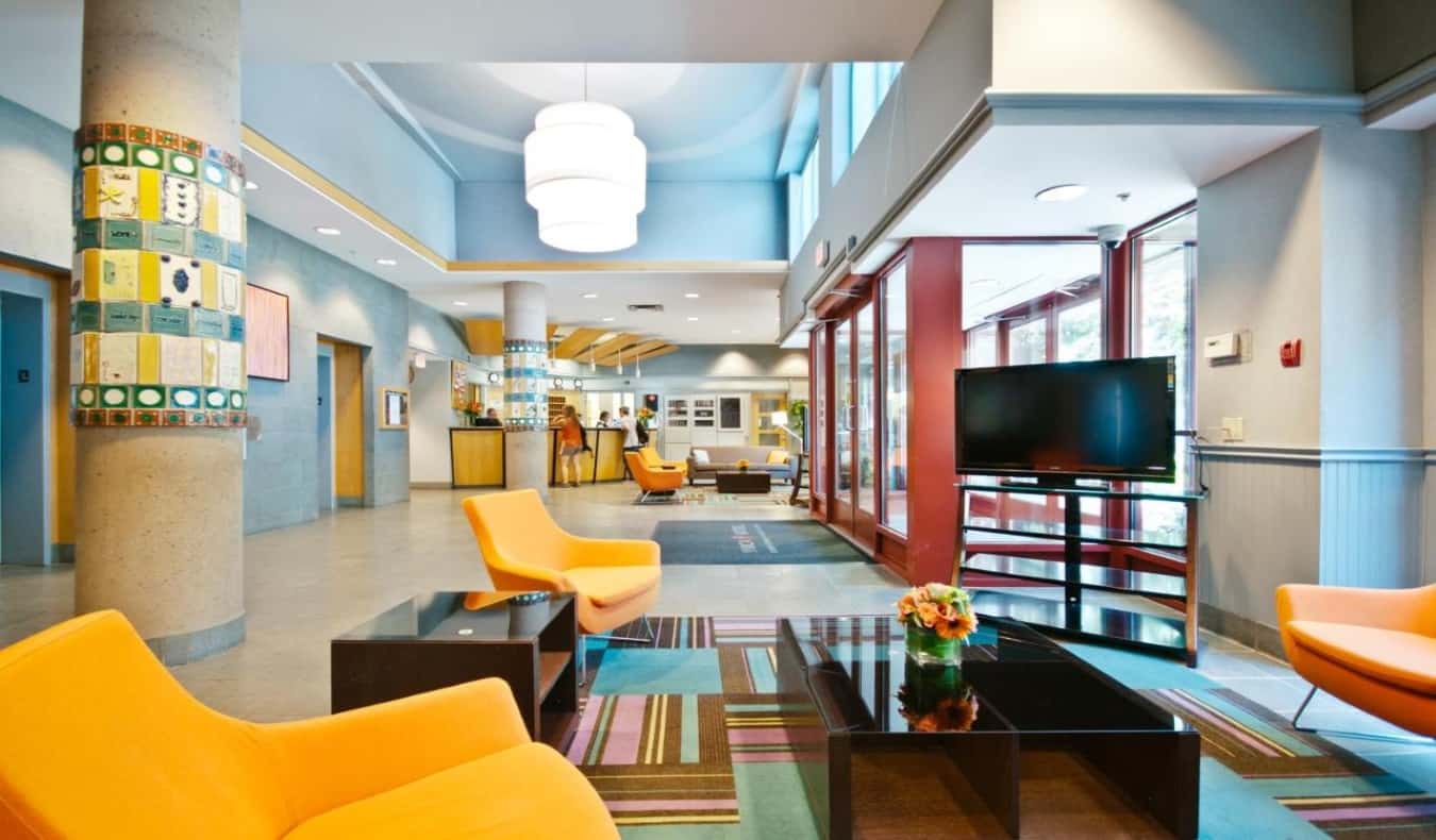 Brightly colored lobby with easy chairs and coffee tables at YWCA Hotel in Vancouver.