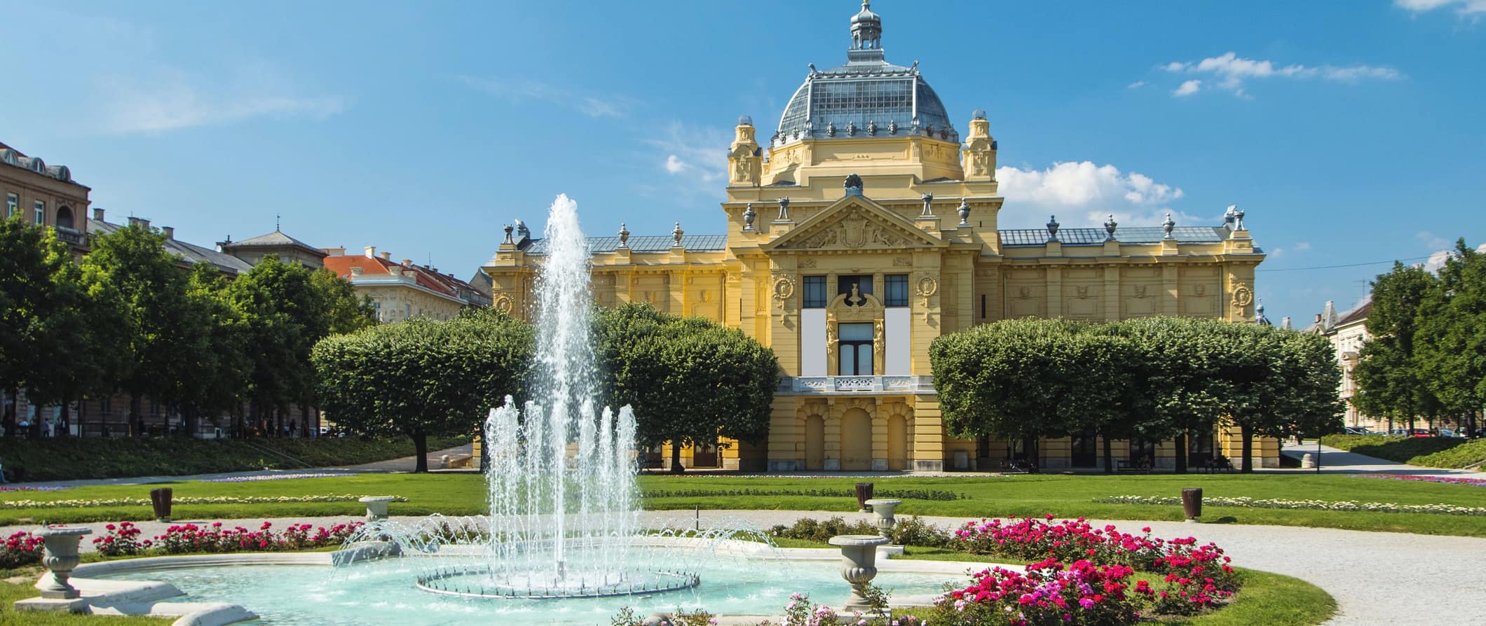 A large historic building with a water fountain in Zagreb, Croatia
