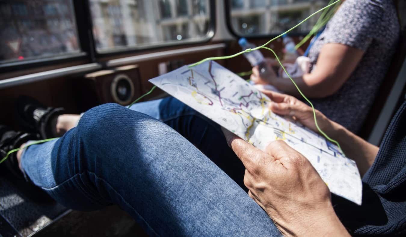 Someone listening to headphones while looking at a map