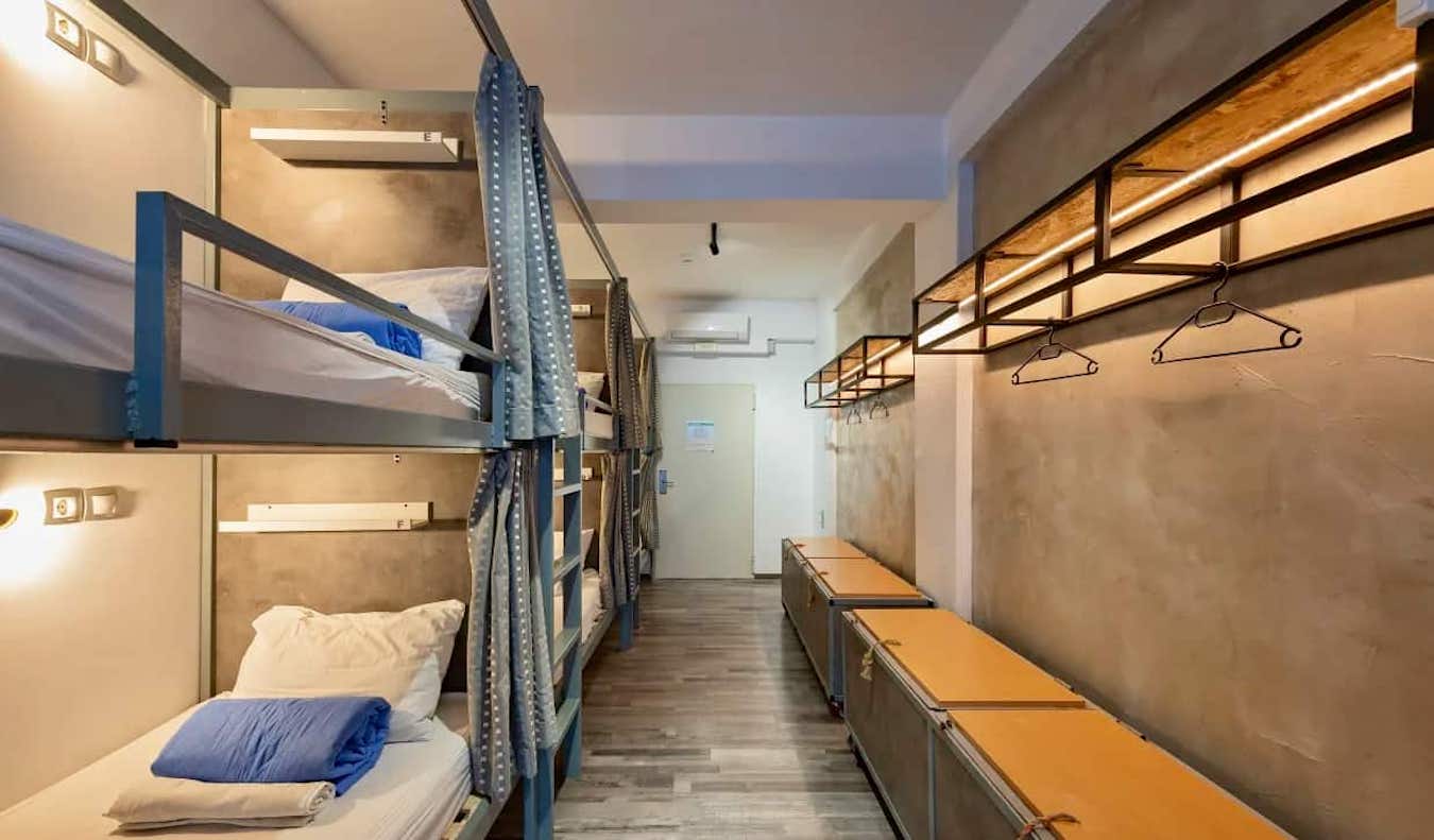 Comfortable bed with curtains in dormitory room at Bedbox hostel in Athens
