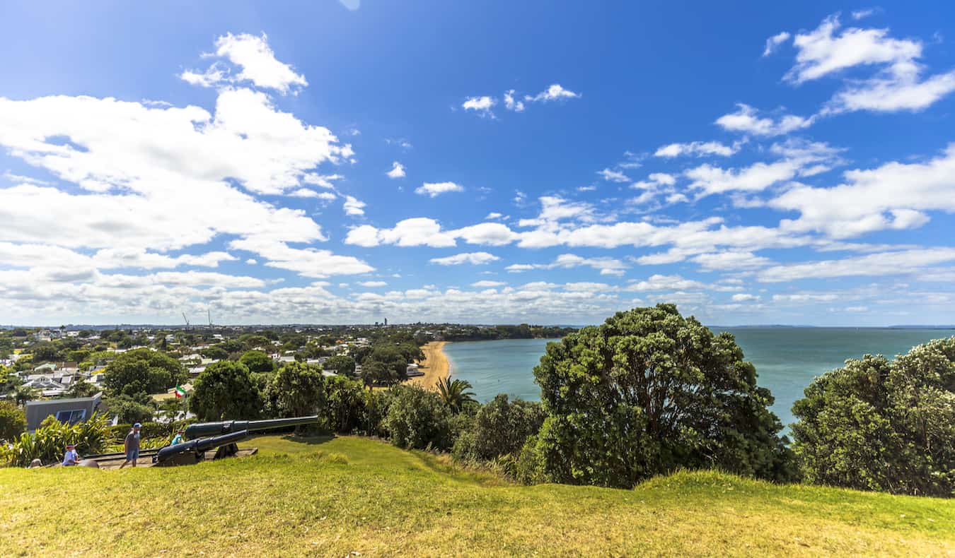 Njerëzit që ecin në kodrën me bar në Devonport me pamje nga Auckland, Zelanda e Re