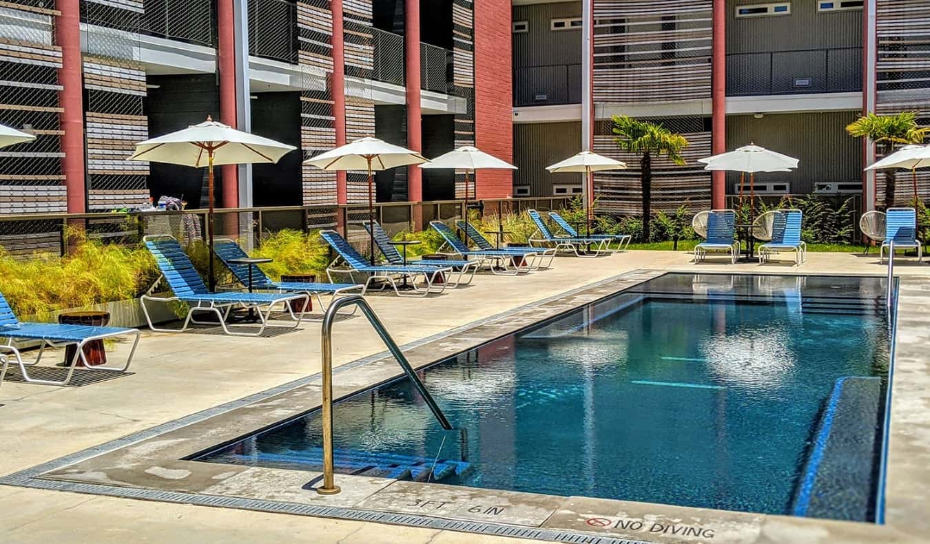 Petite piscine extérieure entourée de chaises longues à l'East Austin Hotel.