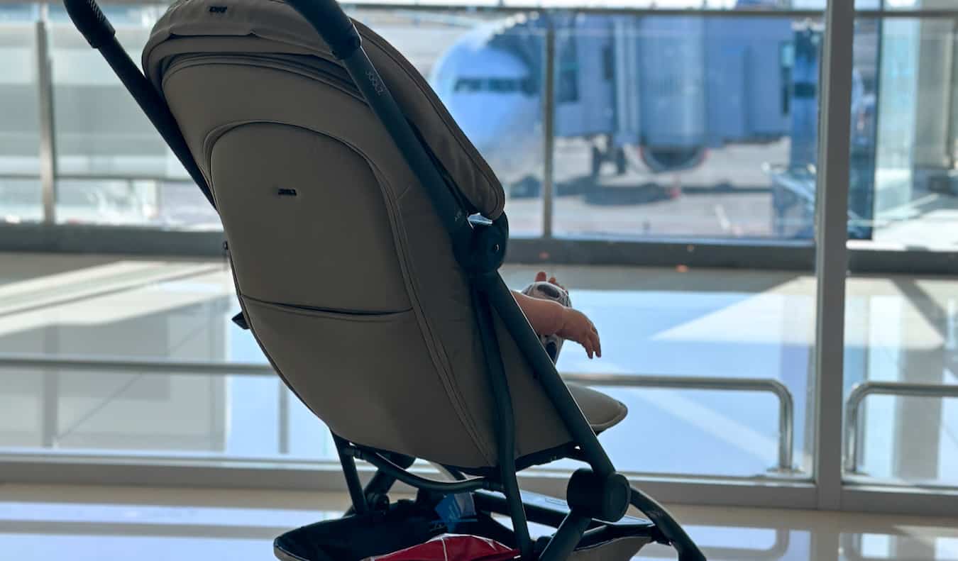 A baby stroller parked in a airport during a layover