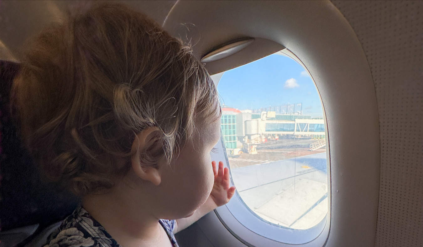 Un jeune bébé regardant par le hublot d'un petit avion.