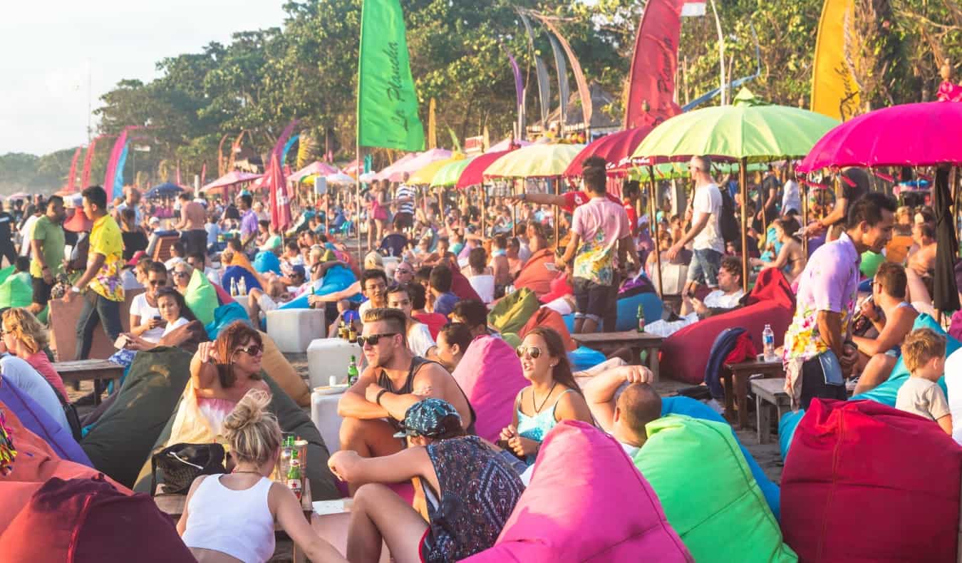 Beach completely packed with tourists sitting in bean bag chairs in Bali, Indonesia