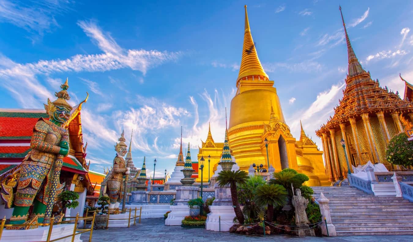 golden spires of temples in Bangkok, Thailand set against a blue sky