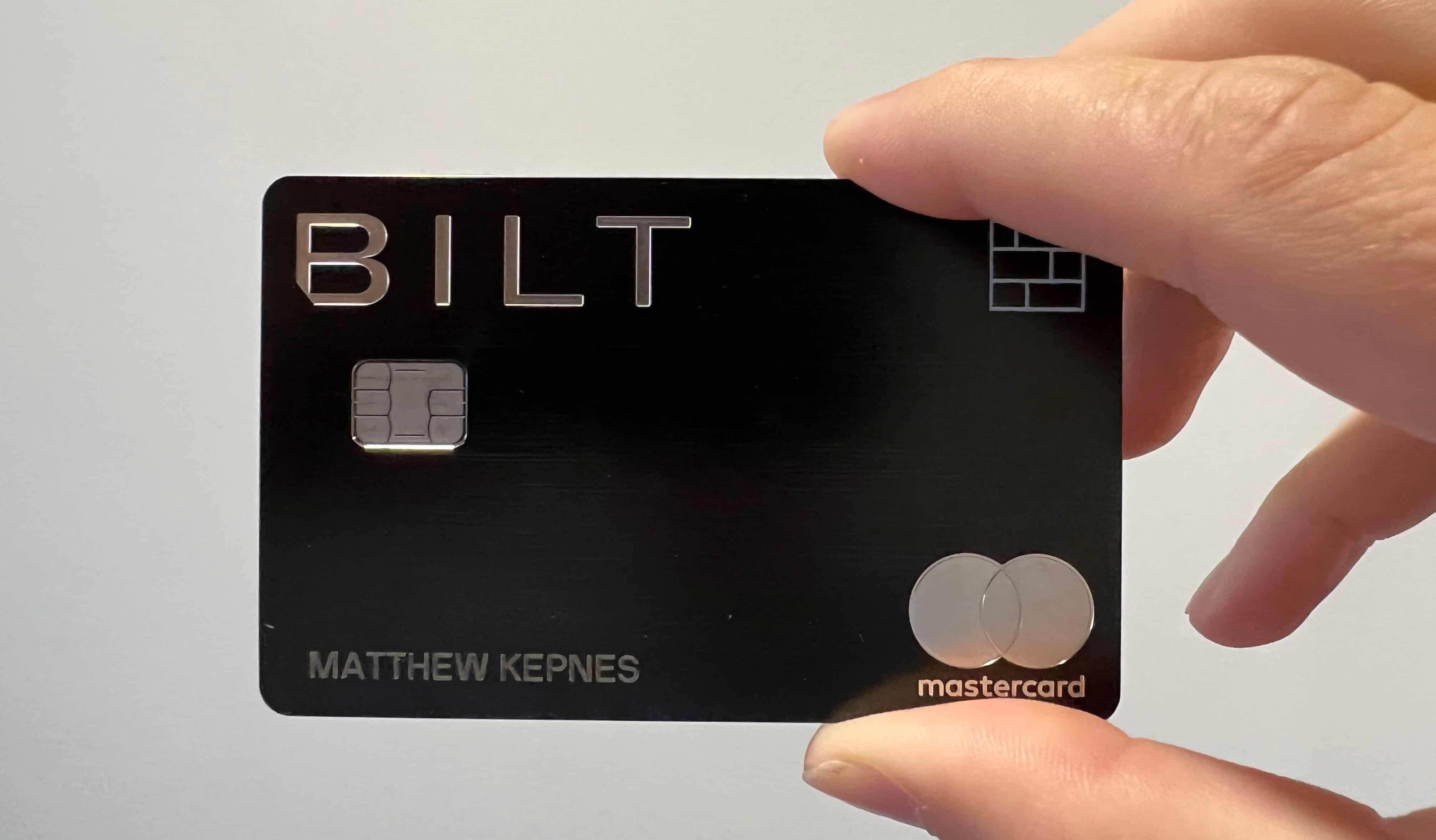 Nomadic Matt's Bilt Mastercard is held up in front of a white wall