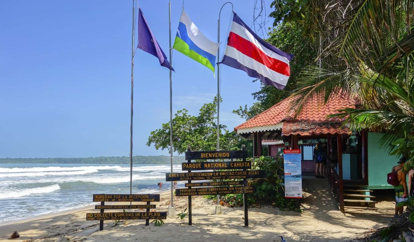 Entrance to Cahuita National Park in Costa Rica with signs and flags flying