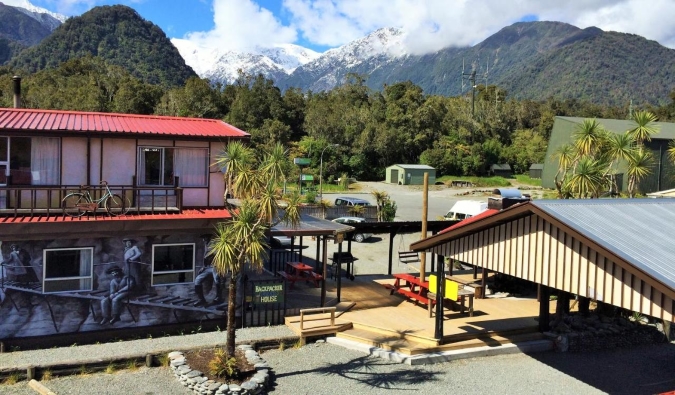 Exterior of Chateau Backpacker & Motels budget accommodation with forest in the background, in Franz Josef, New Zealand