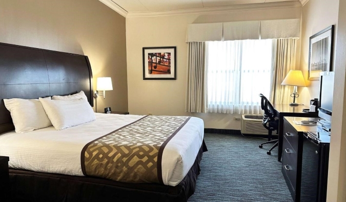 Guest room at Chicago South Loop Hotel with a queen sized bed, desk, and TV