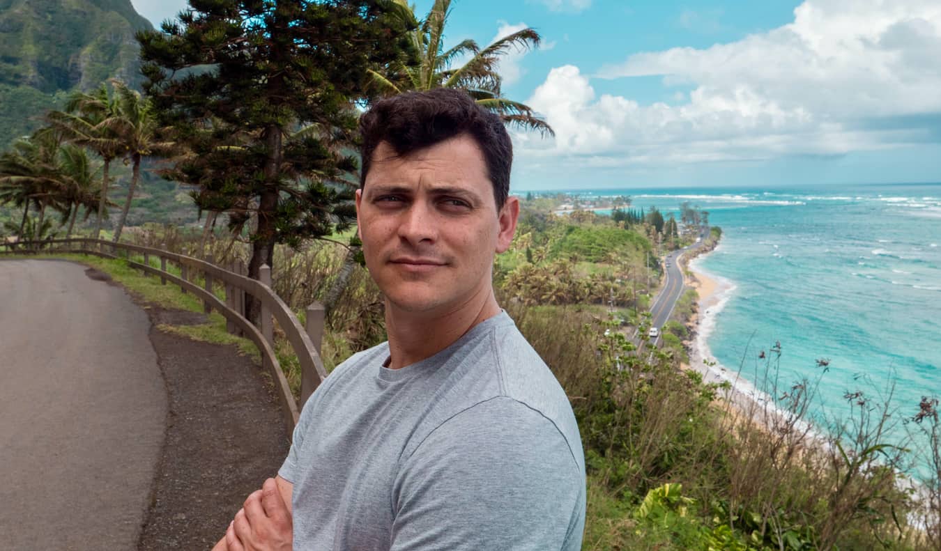 Nomadic Matt posing for a photo along the winding road of Hawaii