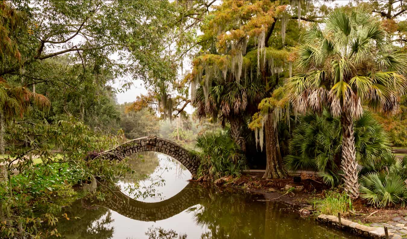 An old bridge over the water in the lush greenery of City Park, NOLA