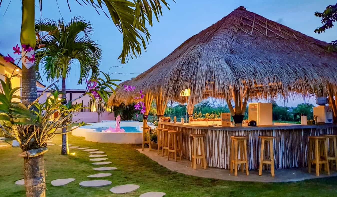 The outdoor pool and a small bar on a sunny day at the Clandestino hostel in Canggu, Bali