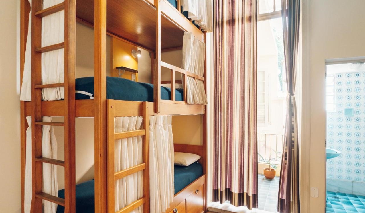Three-tier wooden bunk beds at Discovery Hostel in Rio de Janeiro, Brazil