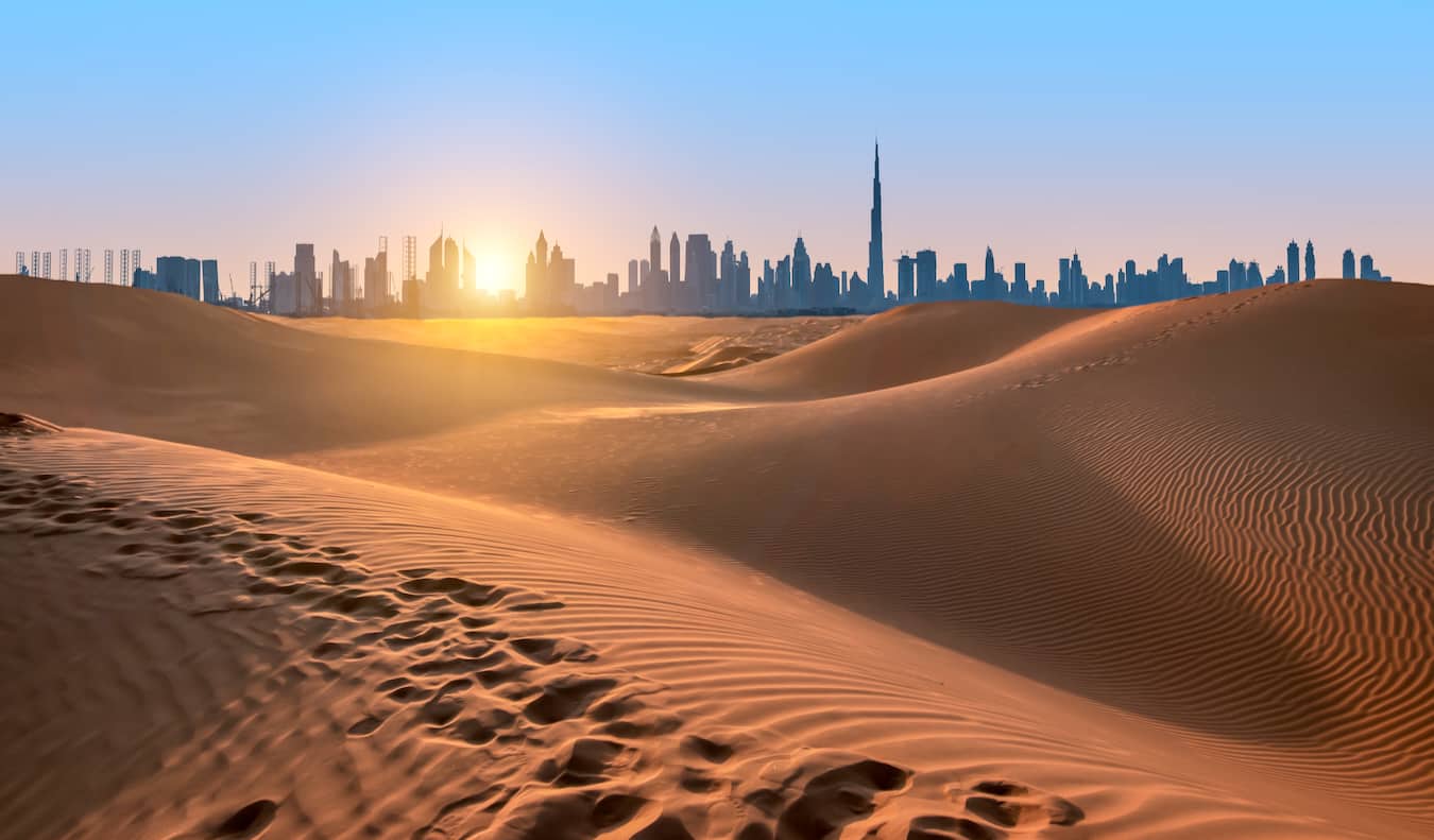 The towering skyline of downtown Dubai, as seen from the golden sand dunes just outside the city