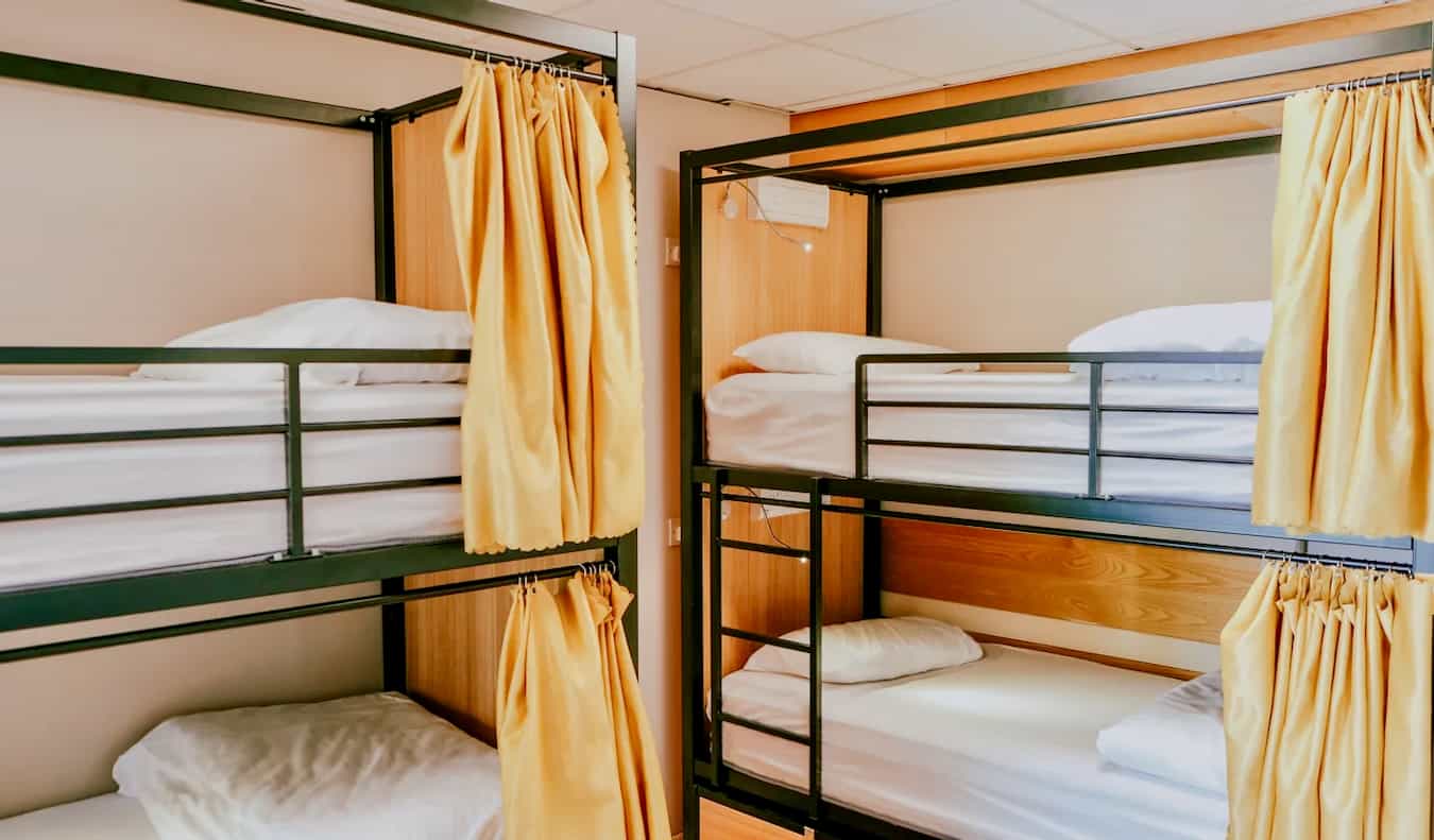 Beliches com cortinas em um dormitório do Garden Lane Hostel em Dublin, Irlanda