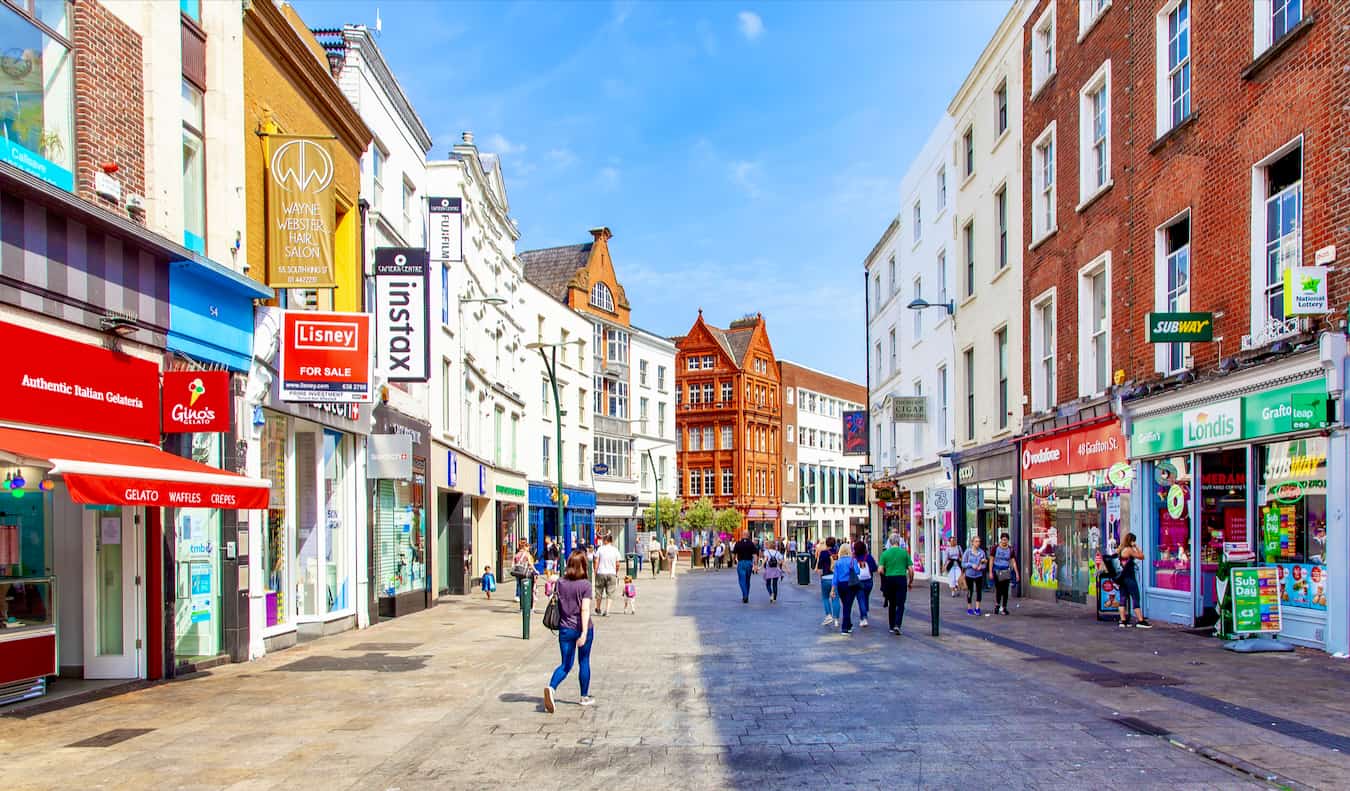 A sunny day in the Old Town of Dublin, Ireland, as people walk around and shop