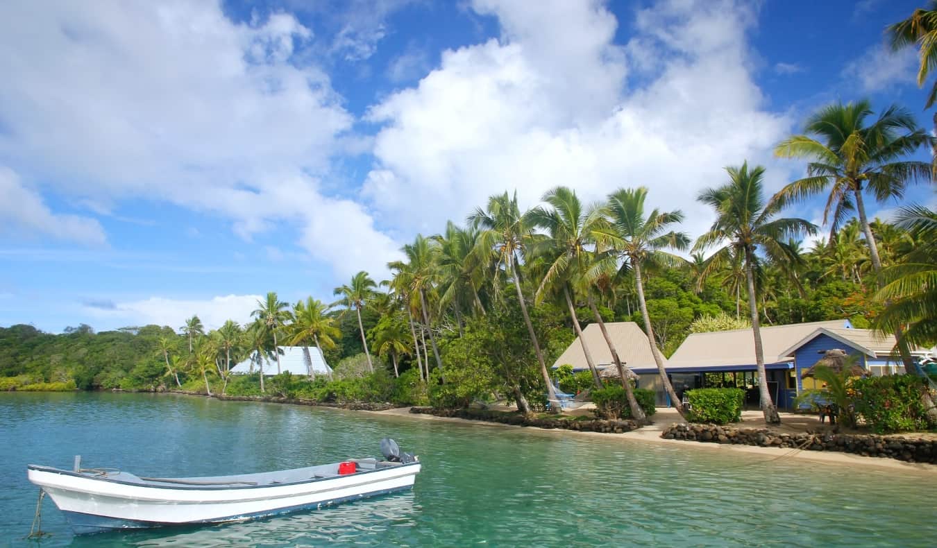 A boat in the clear blue water off the coast of an island in Fiji