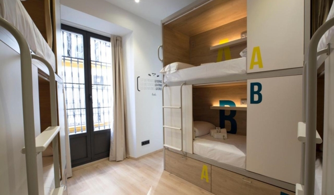 Modern pod-style bunk beds in a brightly-lit room at For You Hostel in Sevilla, Spain