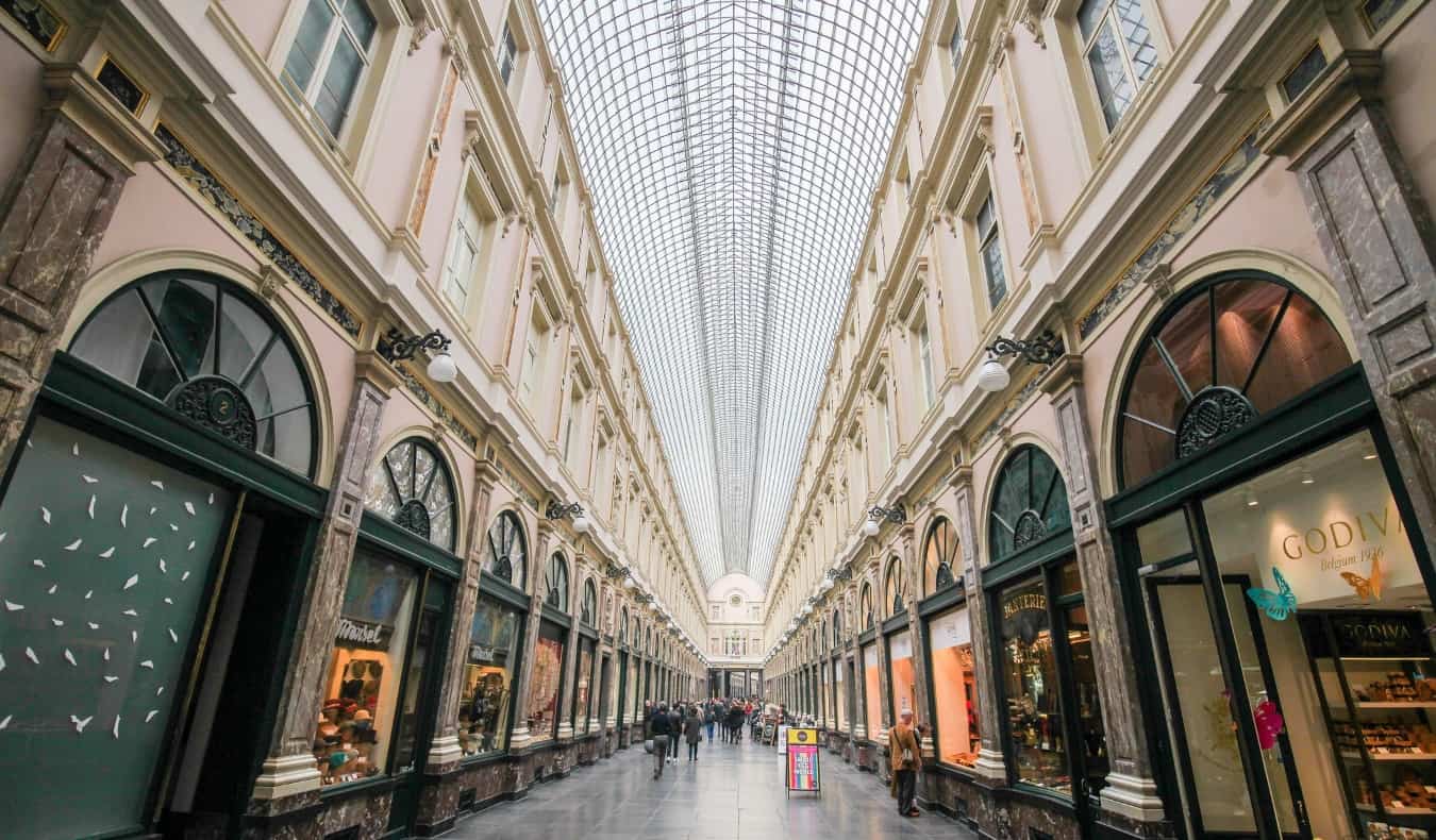 The glass-paneled roof and arched shop doorways of Galeries Royales Saint-Hubert in Brussels, Belgium
