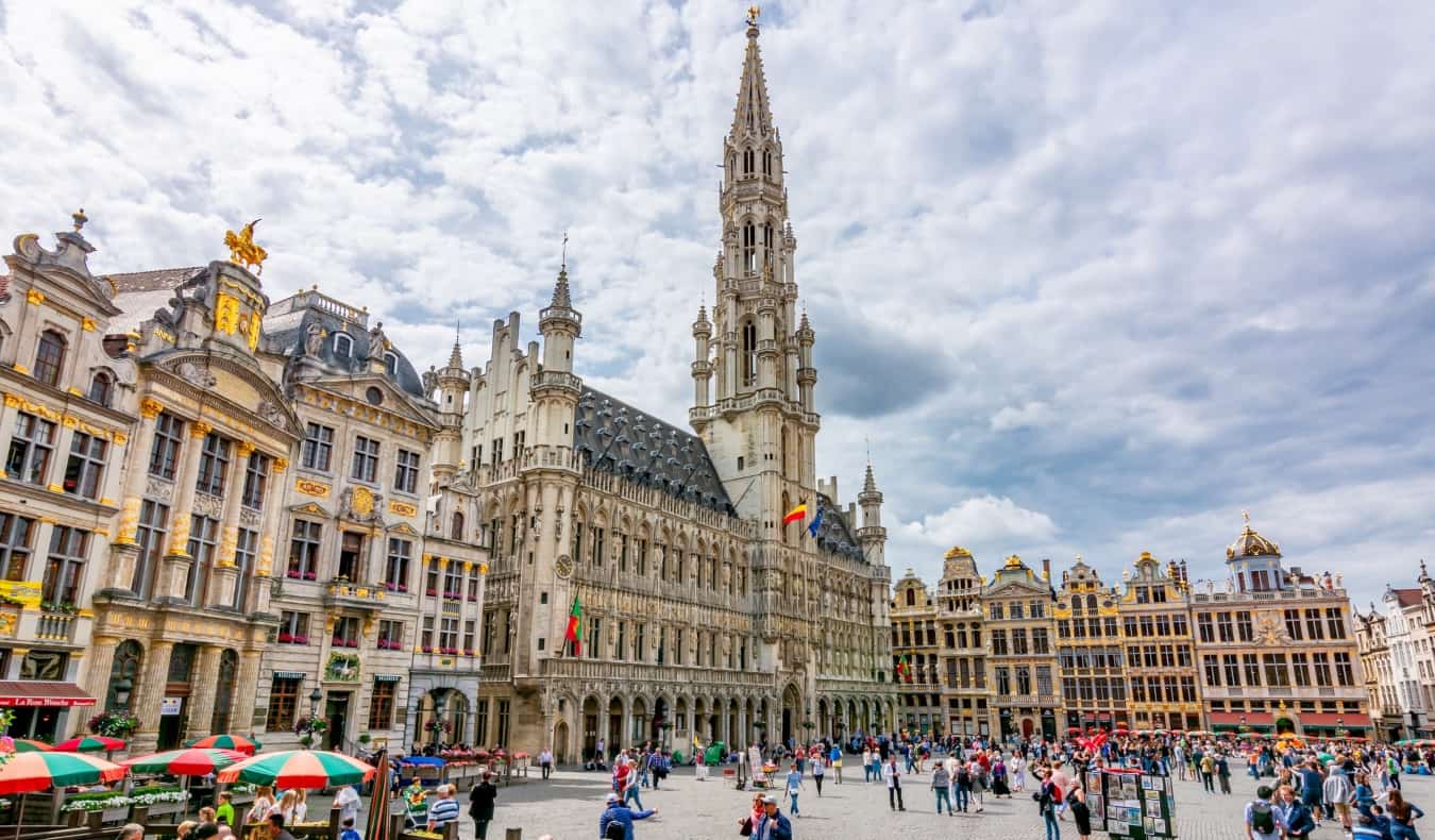 People walking around Grand Place, the central square in Brussels, Belgium lined with gilded and ornate buildings