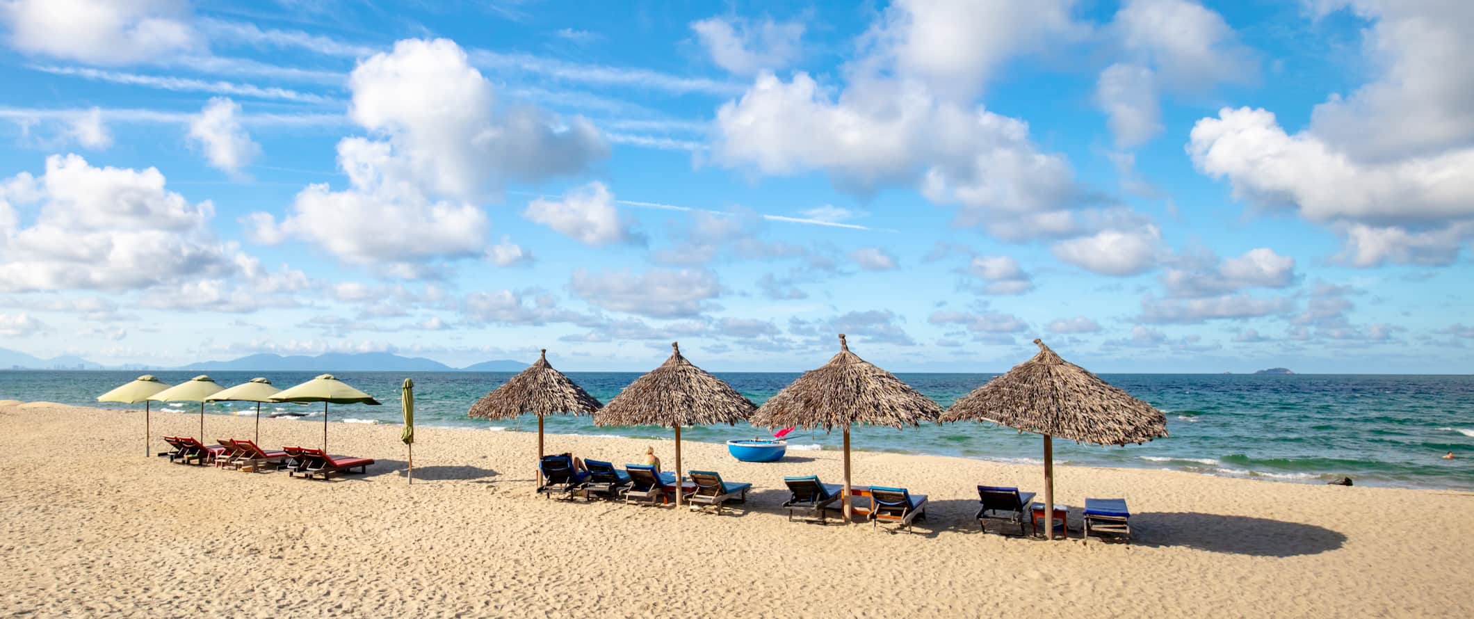 The beautiful beach with chairs and umbrellas near sunny Hoi An, Vietnam