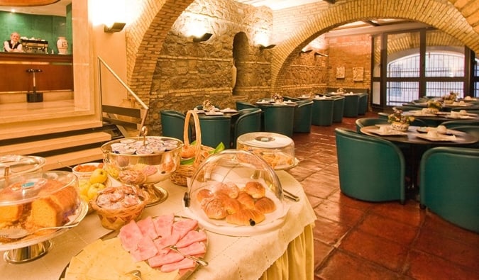 Breakfast buffet in the dining area with stone arched ceilings at Hotel Laurentia in Rome, Italy
