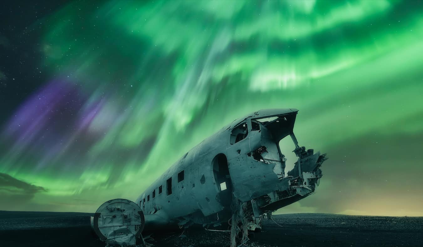 The stunning Northern Lights in Iceland at night over the famous plane crash wreck