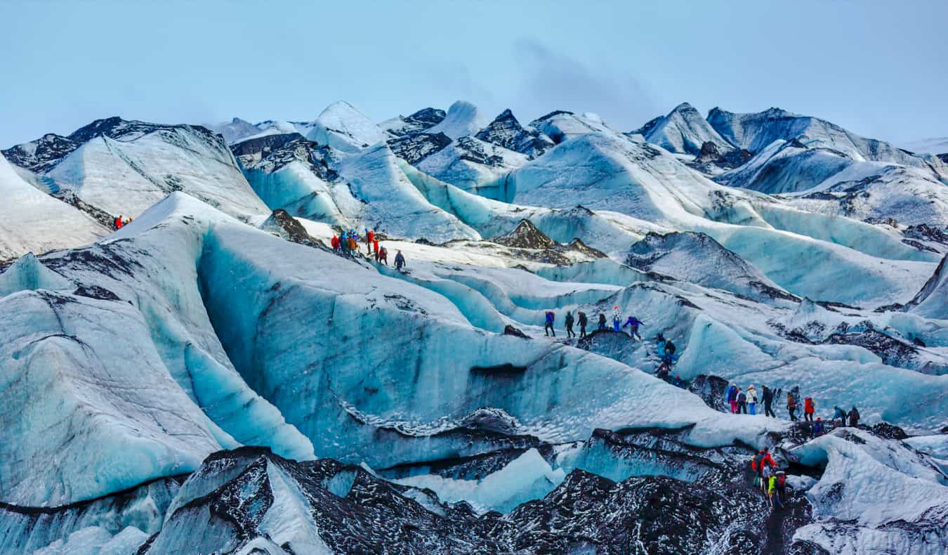 People hiking on a stunning, massive glacier in rugged Iceland