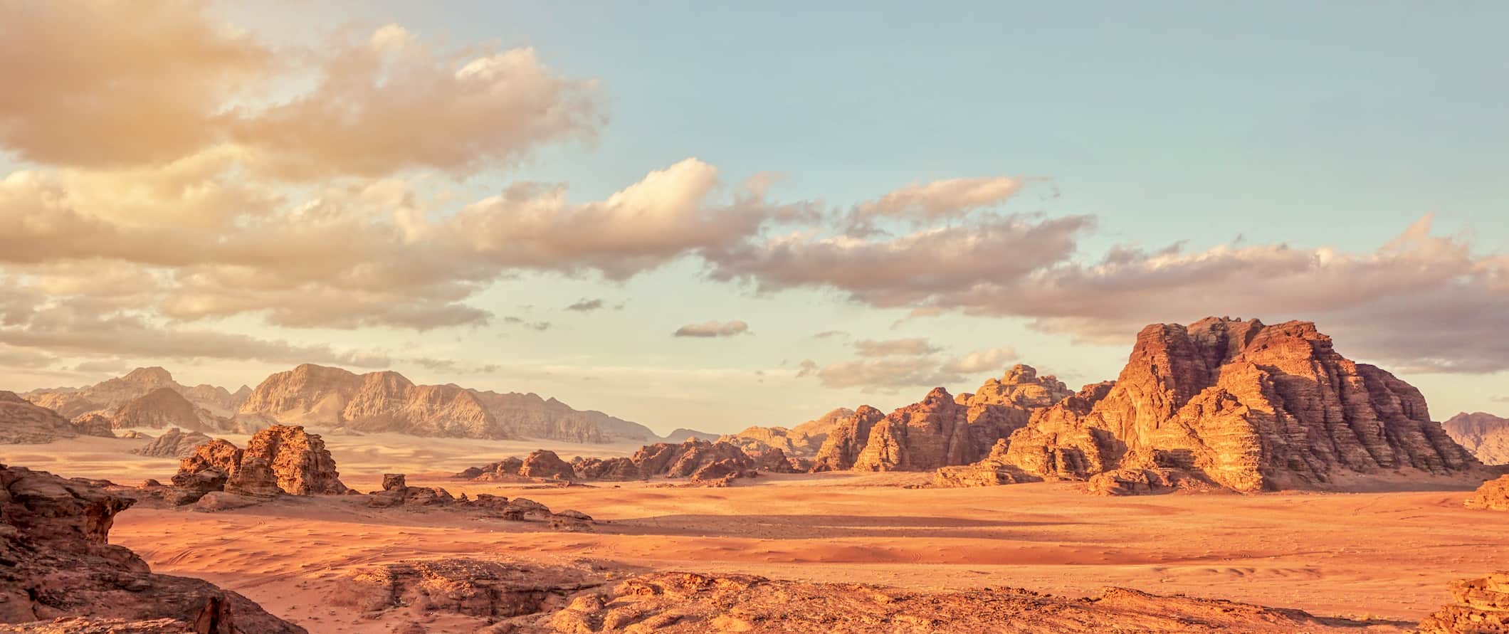 The rugged, desert landscape of Wadi Rum in Jordan sprawling into the horizon