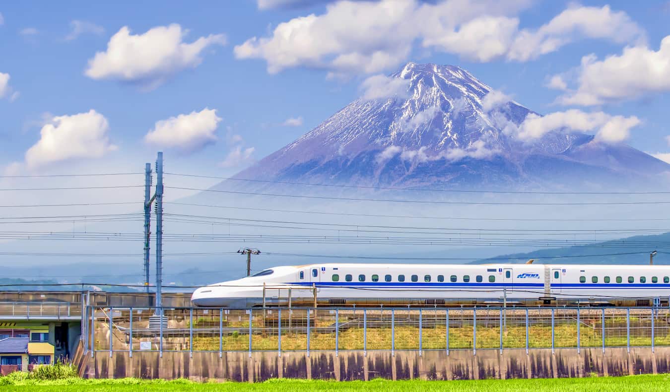 A bullet train crosses in front of the famous Mount Fuji in the background in Japan