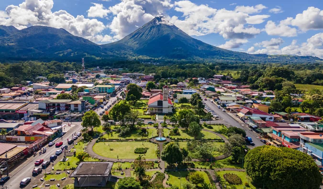 Pemandangan udara kota La Fortuna dengan gunung berapi Arenal di latar belakang pada hari yang cerah di Kosta Rika