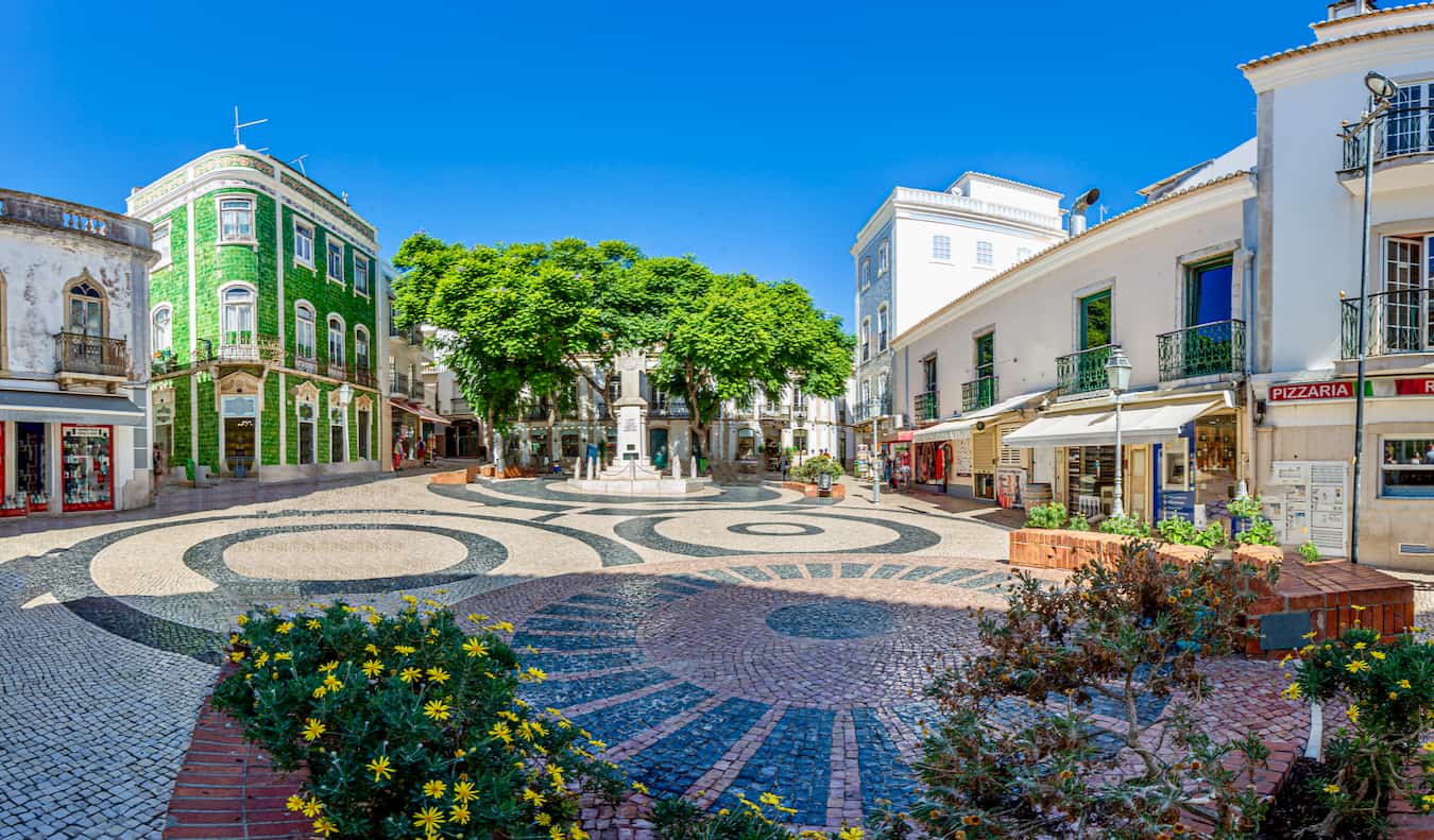 A quiet square in sunny Lagos, Portugal, with lots of old buildings and trees