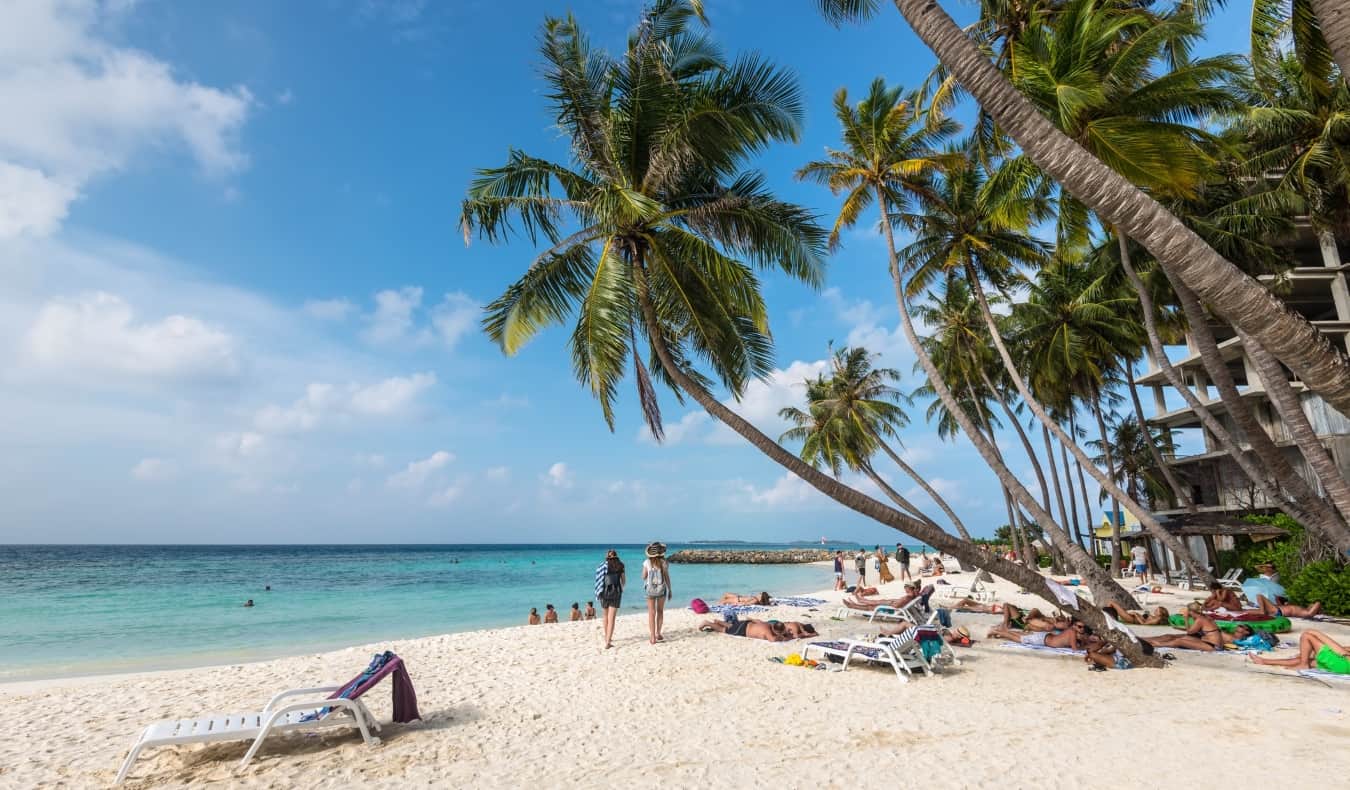 People lounging on the beach in Maafushi in the Maldives