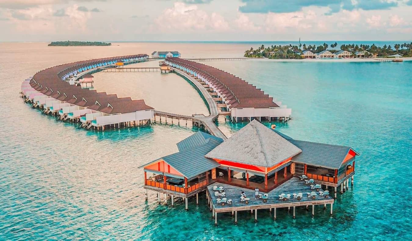 The stunning, clear tropical blues waters of the Maldives along a narrow white-sand beach