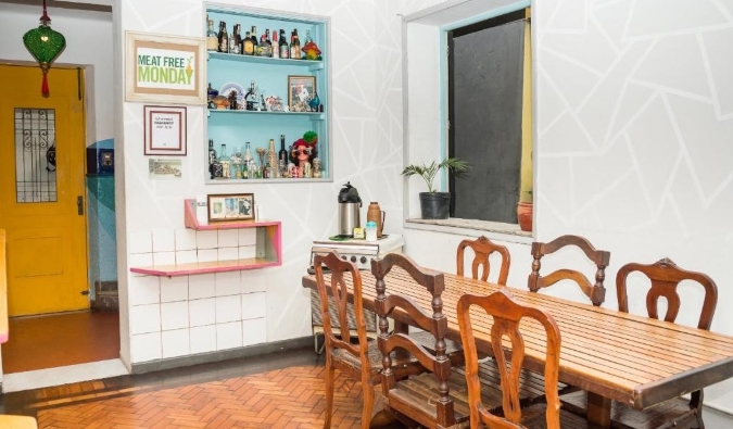 Rustic kitchen with a wooden table and chairs and Mambembe Hostel in Rio de Janeiro, Brazil
