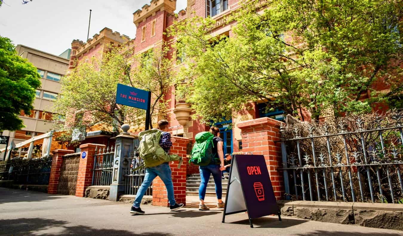 People walking into the huge Mansion Hostel in Melbourne, Australia